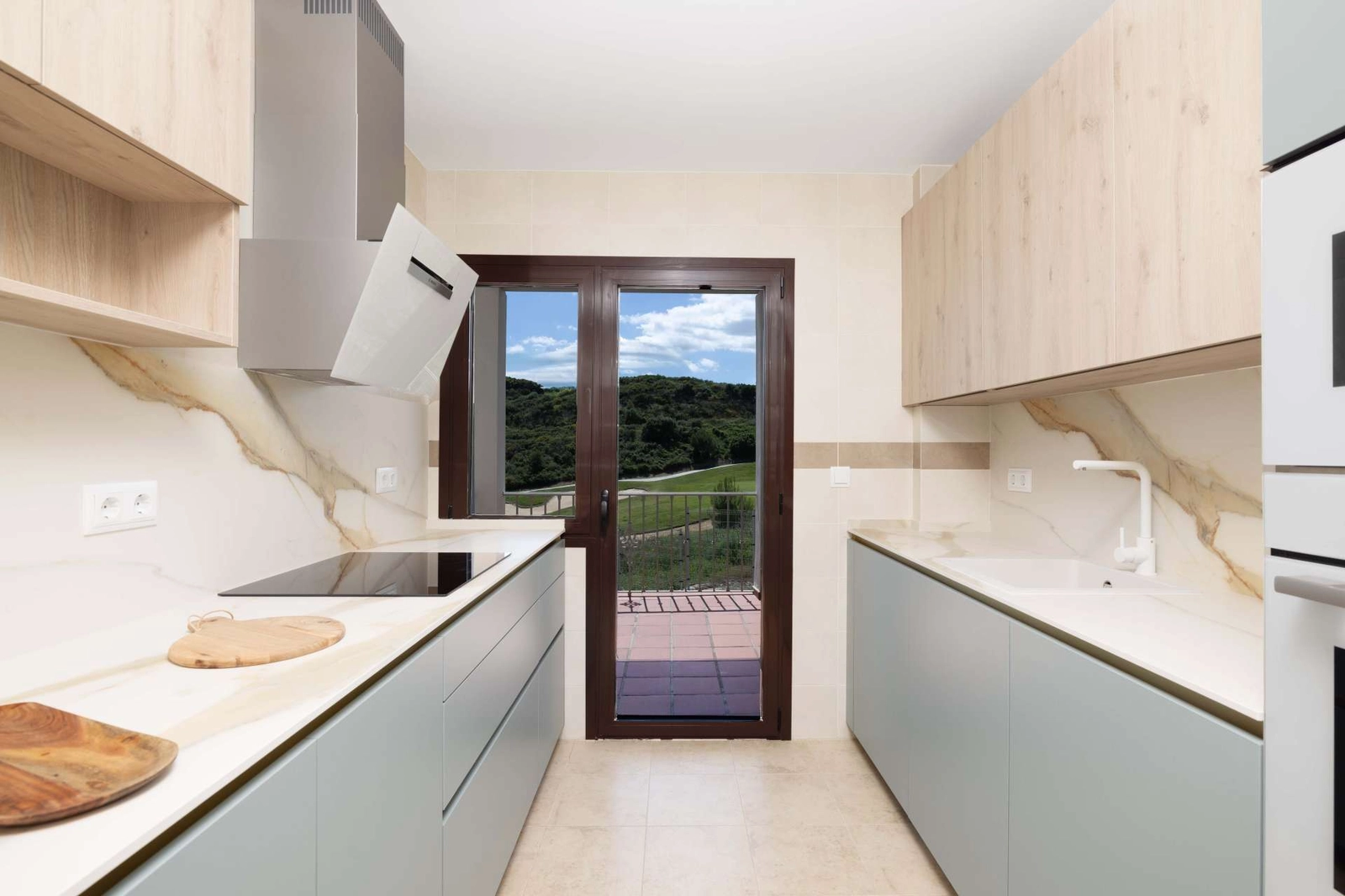 Die moderne Küche ist funktional und stilvoll gestaltet und bietet Blick ins Freie.