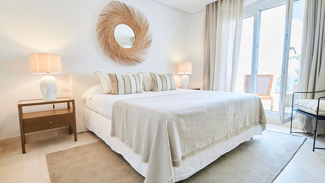 Das ruhige Hauptschlafzimmer, ein Rückzugsort mit natürlichem Licht und direktem Zugang zur Terrasse.