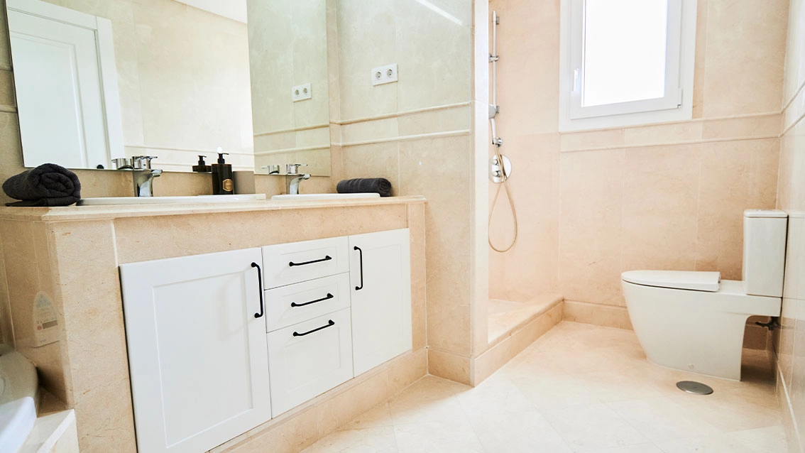 Ein elegantes Badezimmer mit hochwertigen Materialien und modernen Armaturen für ein Spa-ähnliches Erlebnis zu Hause.