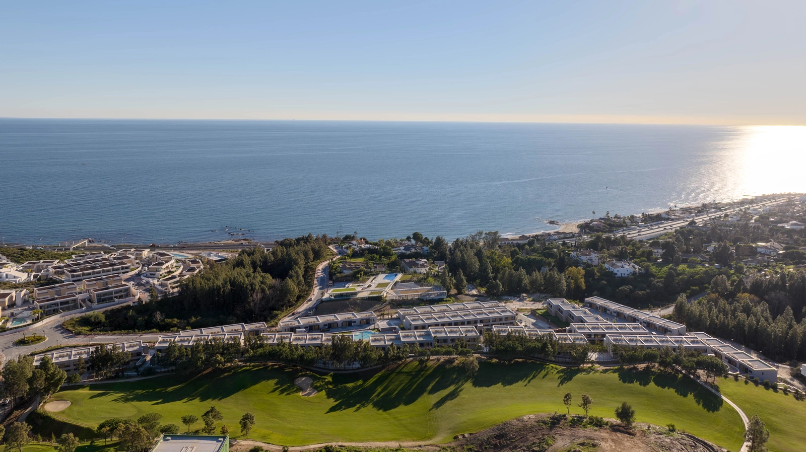 Eine Luftaufnahme von Evergreen Homes, perfekt gelegen zwischen den grünen Fairways des Golfplatzes und dem blauen Mittelmeer.