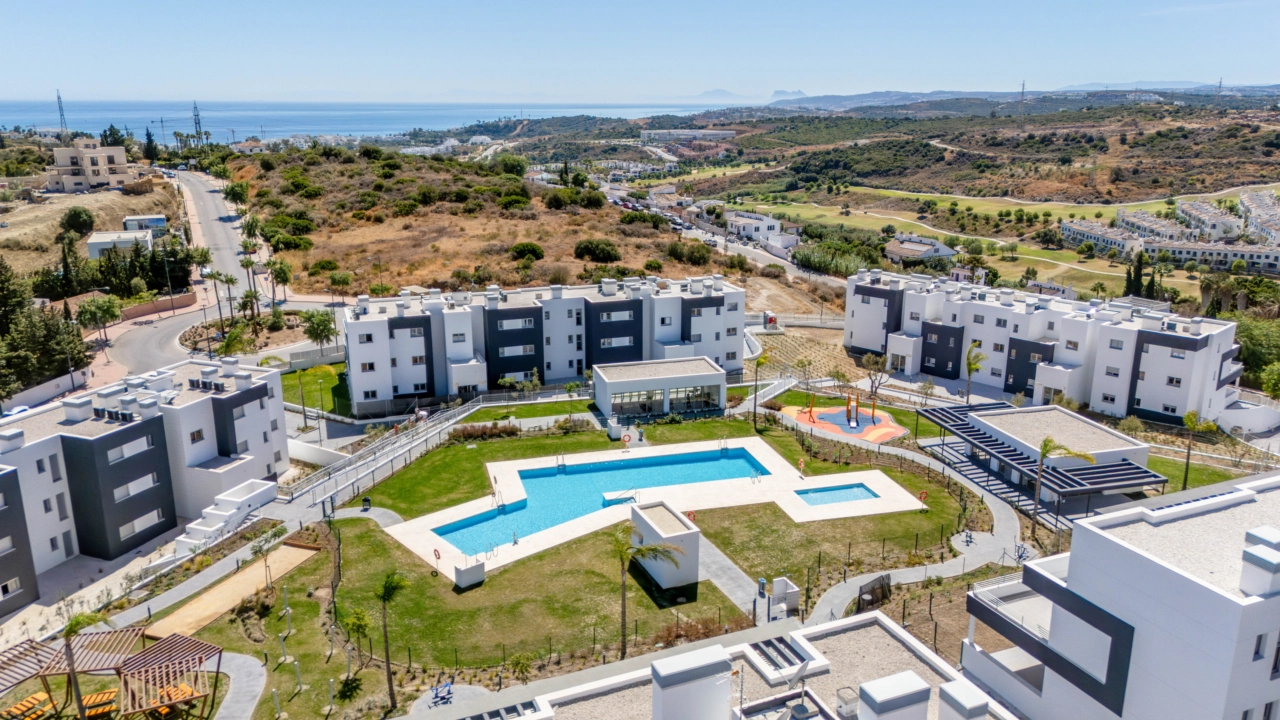 Eine wunderbare Perspektive der fertiggestellten Anlage, die die Schwimmbäder und Grünflächen mit dem Meer am Horizont zeigt.