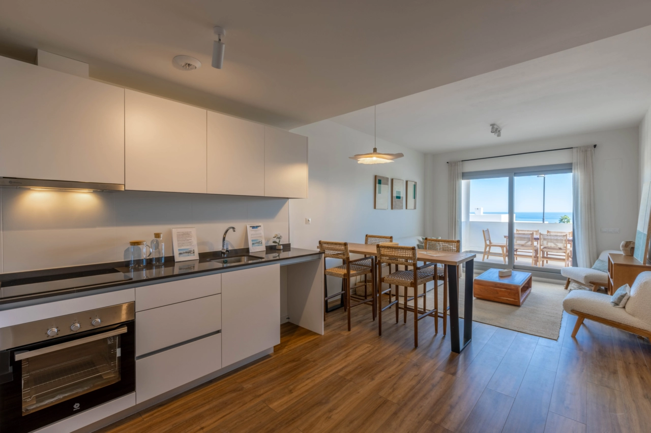 Eine moderne, voll ausgestattete Küche öffnet sich zum Wohnbereich und schafft so ein helles und geselliges Herzstück des Zuhauses.