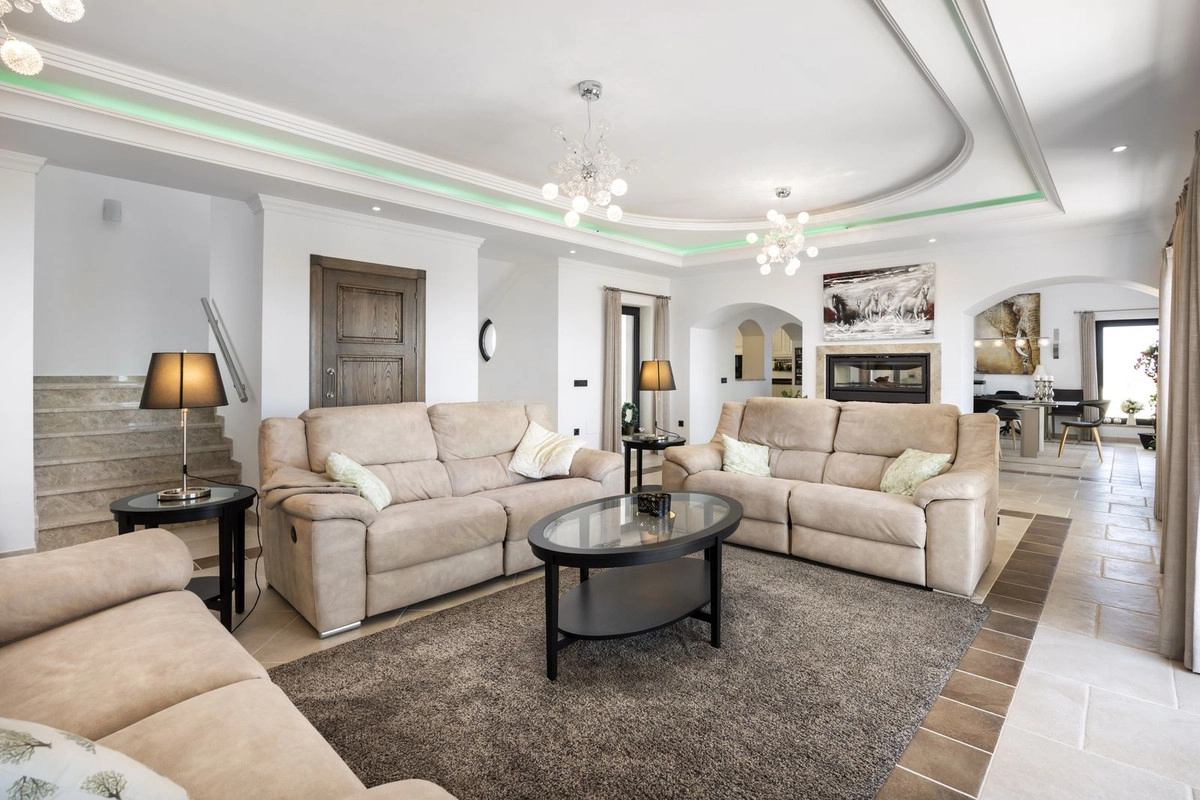 Das elegante und geräumige, lichtdurchflutete Wohnzimmer ist auf Komfort und Entspannung ausgelegt.