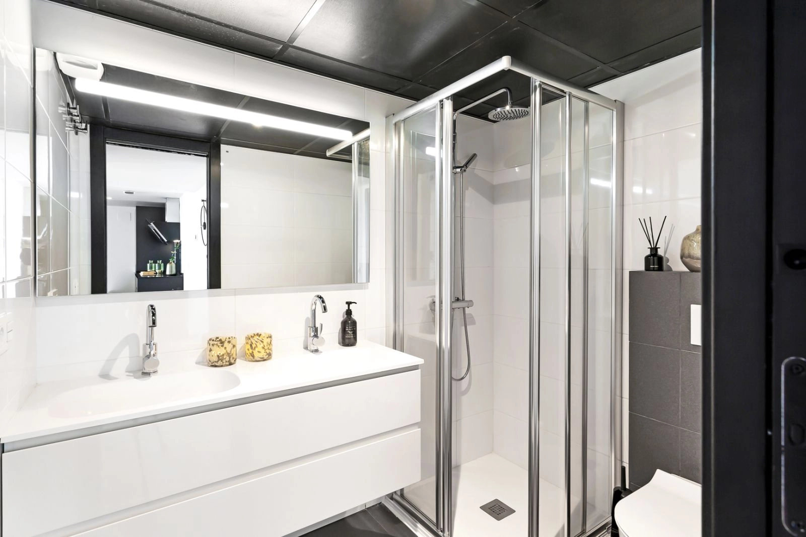 Ein stilvolles und funktionales Badezimmer mit modernen Armaturen, einer ebenerdigen Dusche und hochwertigen Oberflächen.