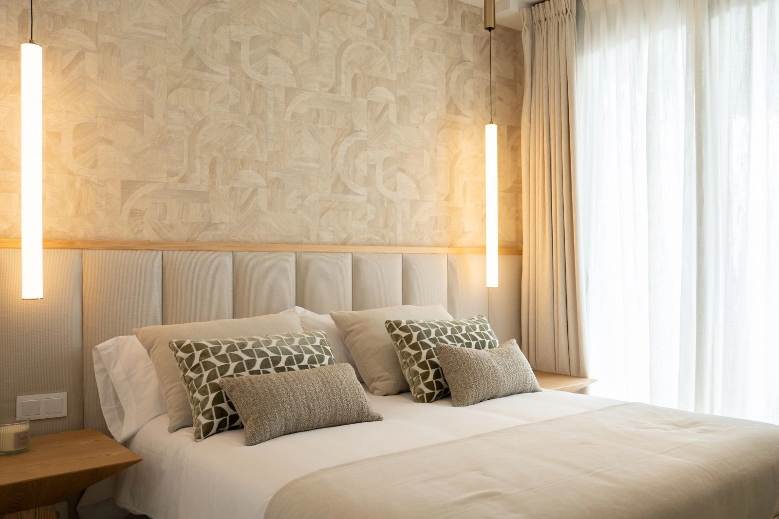 Das Hauptschlafzimmer ist ein friedlicher Rückzugsort, mit eleganten Materialien gestaltet und bietet direkten Zugang ins Freie.