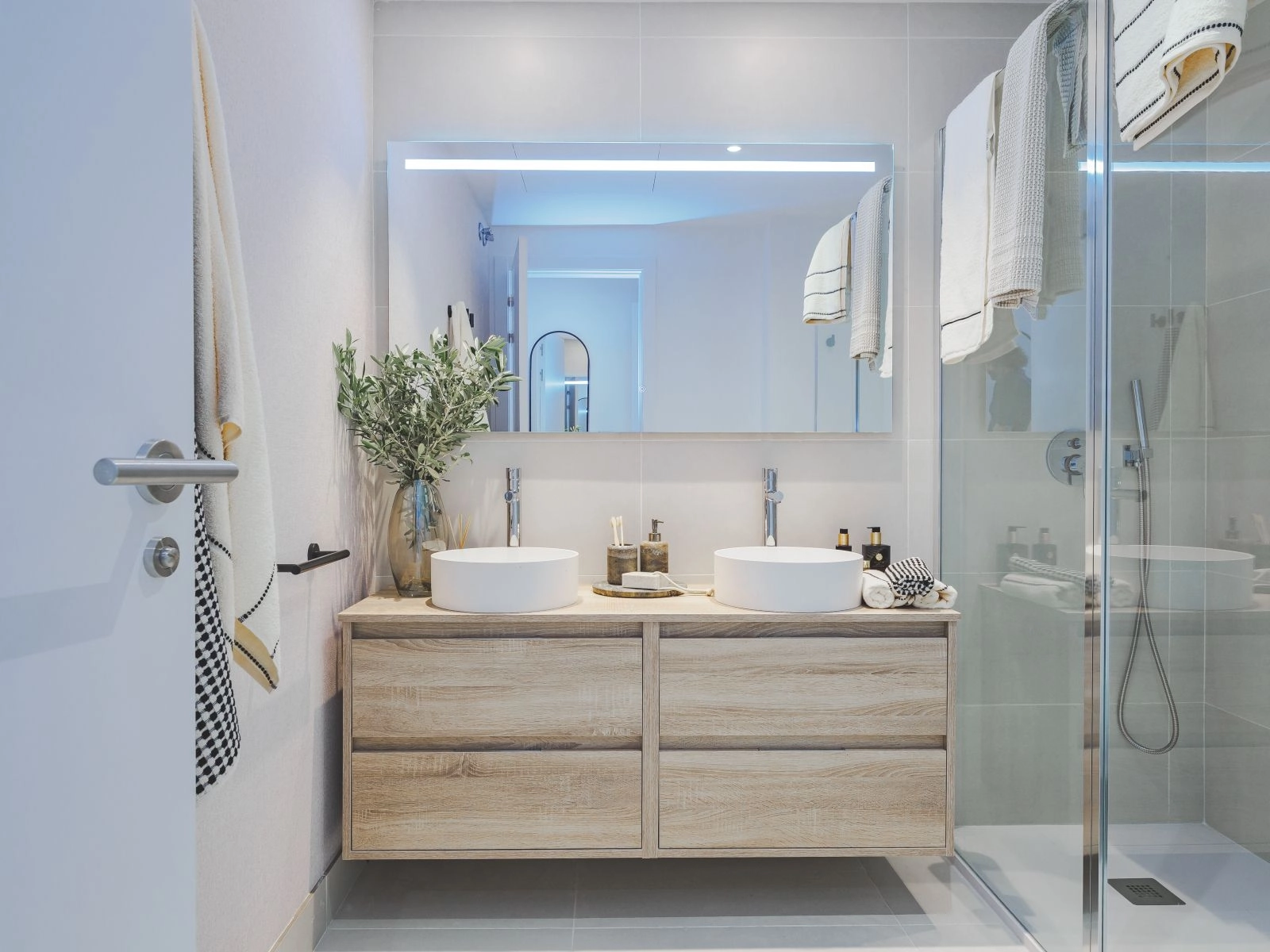 Das Hauptbadezimmer besticht durch modernes Design mit Doppelwaschtisch und hochwertigen Armaturen.