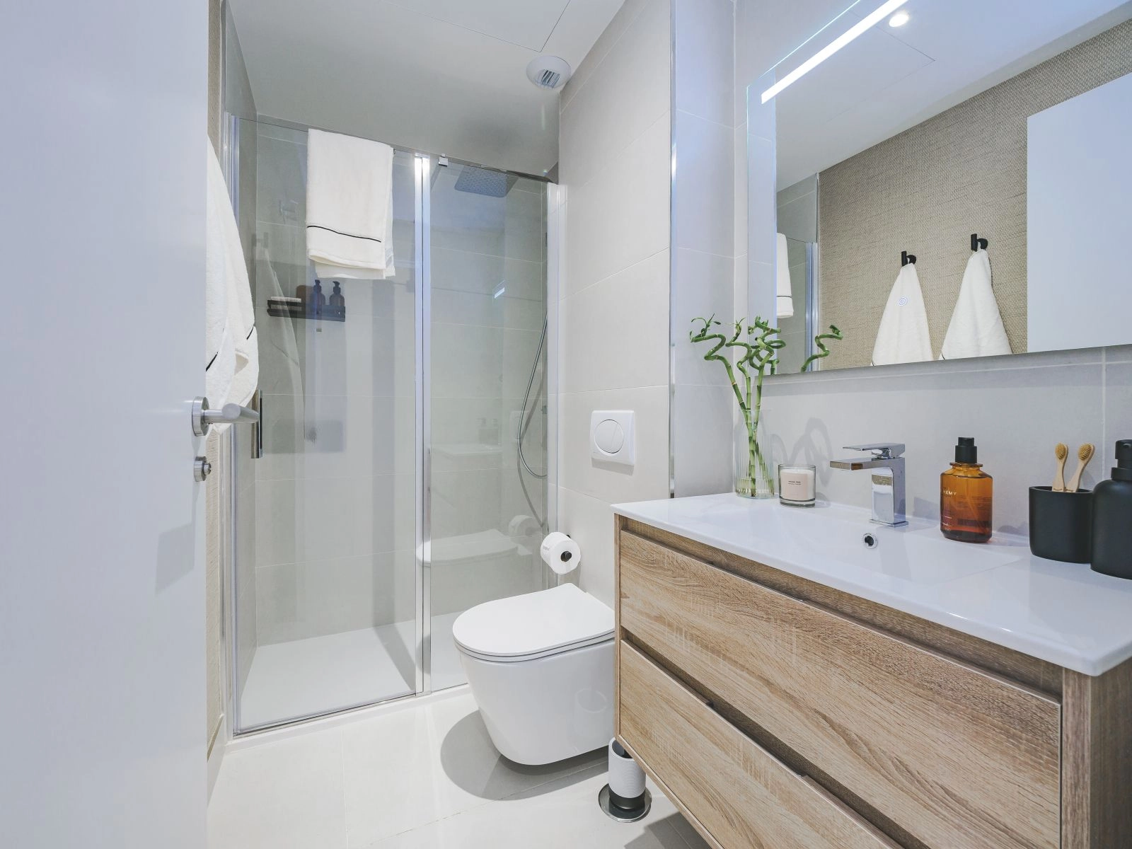 Ein zweites Badezimmer, das modernen Stil und Funktionalität mit einer geräumigen ebenerdigen Dusche vereint.