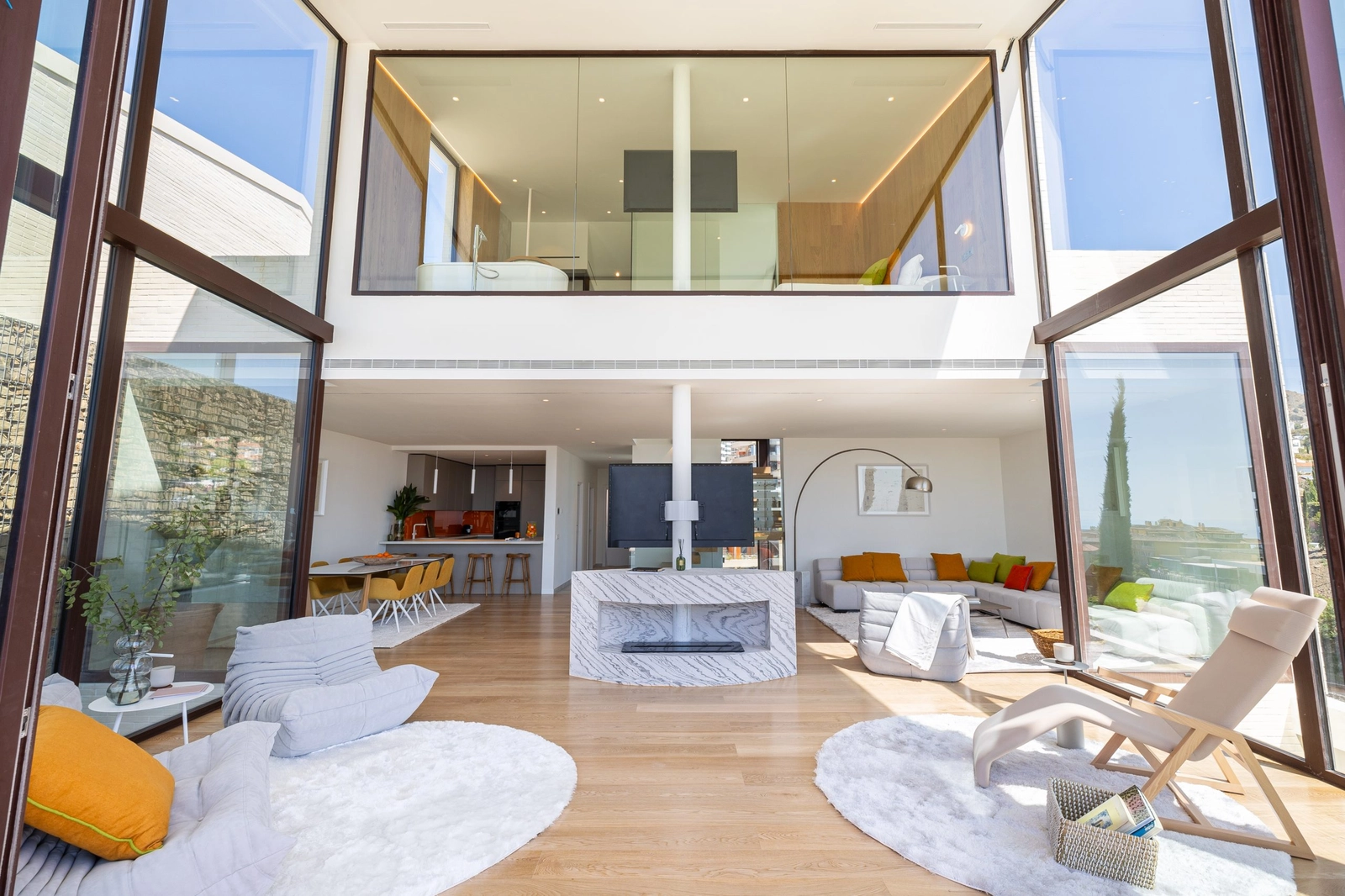 Ein Blick in den doppelhohen Wohnbereich, wo Architektur und Natur miteinander verbunden sind.