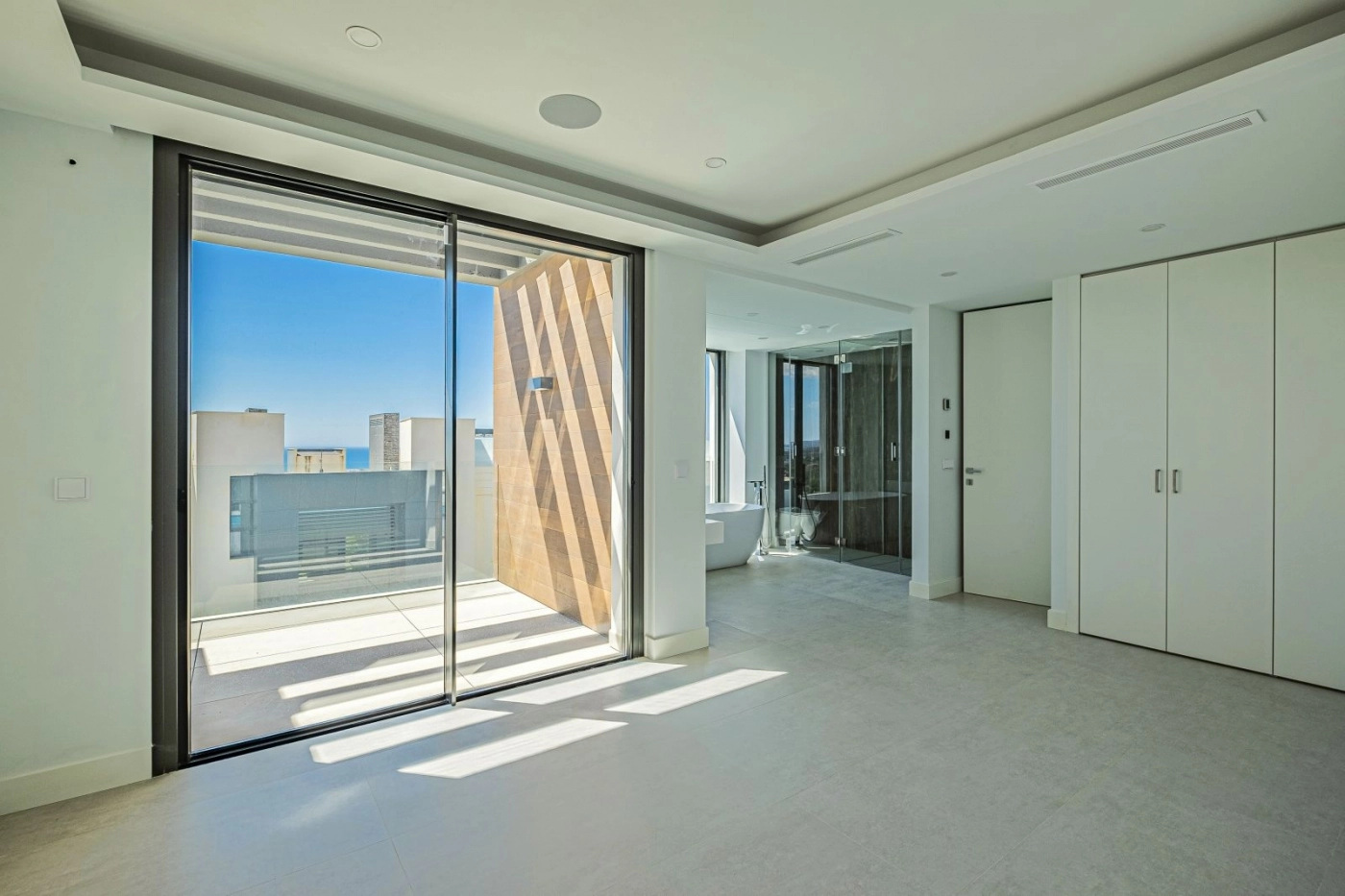 Die Mastersuite bietet einen ruhigen und geräumigen Rückzugsort mit direktem Zugang zu einer privaten Terrasse.