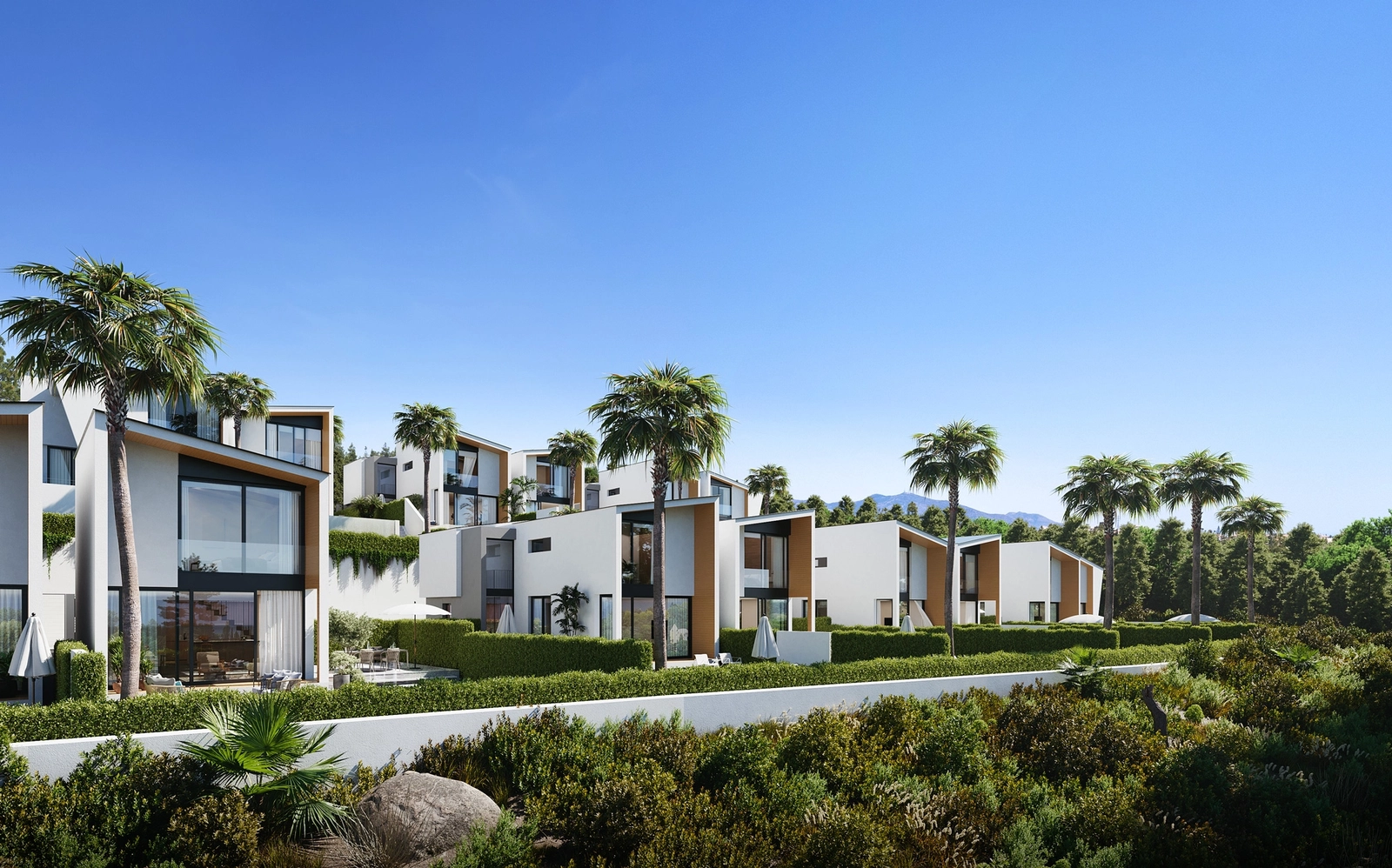 Die markante moderne Architektur der Villen hebt sich vom klaren blauen Himmel und der üppig grünen Umgebung ab.