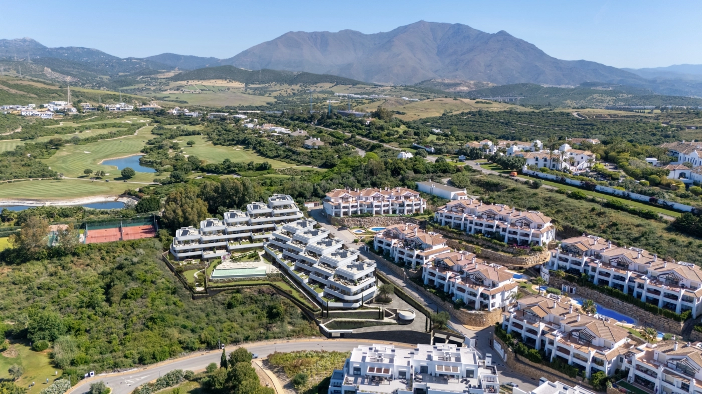 Eine Luftaufnahme zeigt die exklusive Wohnanlage eingebettet zwischen dem Golfplatz Casares und den Bergen.