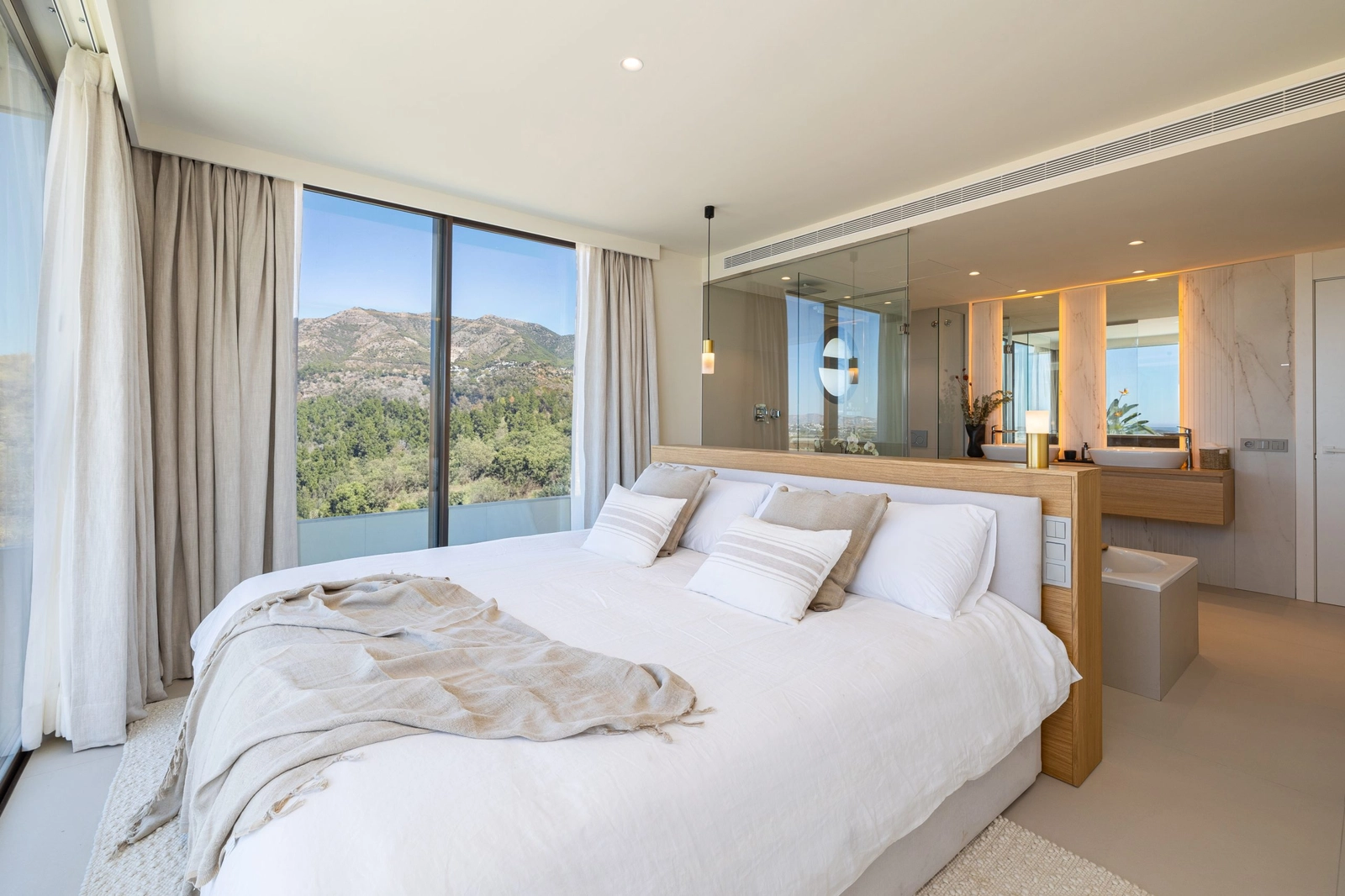 Das Hauptschlafzimmer ist ein friedlicher Rückzugsort mit offenem Bad en suite und großen Fenstern mit beruhigender Aussicht.